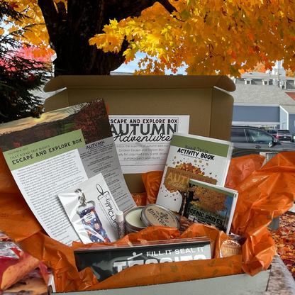The October Escape and Explore box.  Theme is Autumn Adventure.  Curated Items include, Tosssits (a clipon trashbag for the car), a wooden wick candle spice pumpkin cider scent, Lippy Clip smore themed lip balm click with escape adn explore themed lip balm, a autumn adventure themed road trip activity book, a fall road trip scenic drives booklet and a newsletter. 